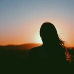 woman watching sunset understanding betrayal trauma