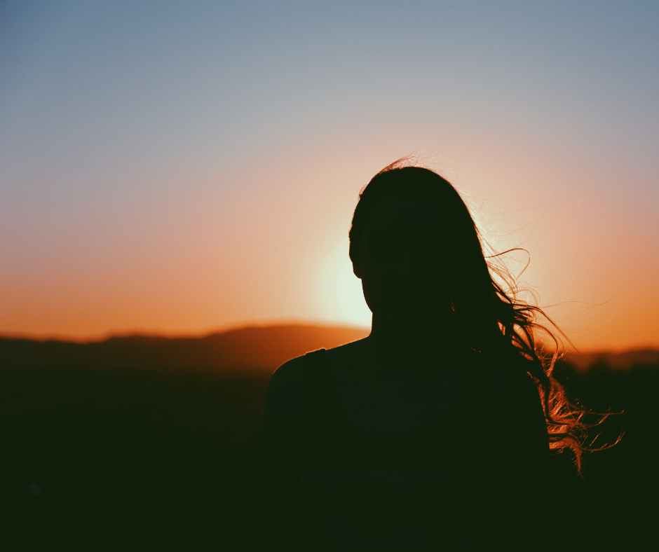 woman watching sunset understanding betrayal trauma
