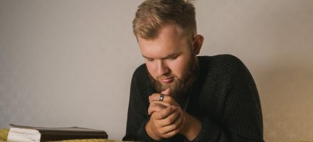 young man kneeling and praying, a pastors secret porn struggle in the church