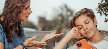 Mom talking to young teen son who is on his smart phone; how to initiate healthy conversations about porn with your teen